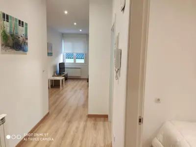 a living room with white walls and a hard wood floor at Villa Trabazos Abellas in Ourense
