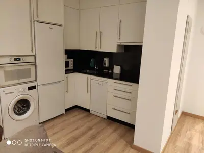 a kitchen with white cabinets and a washer and dryer at Villa Trabazos Abellas in Ourense