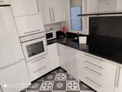 a kitchen with white cabinets and a tile floor at Villa Trabazos Abellas in Ourense