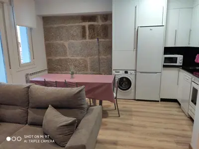 a living room with a table and a kitchen at Villa Trabazos Abellas in Ourense
