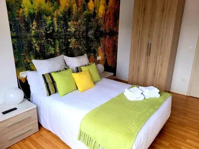 a bedroom with a large bed with yellow and green pillows at Amplio piso con terraza en el Camino y Catedral in Santiago de Compostela