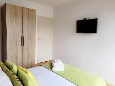 a bedroom with a bed with a tv on the wall at Amplio piso con terraza en el Camino y Catedral in Santiago de Compostela