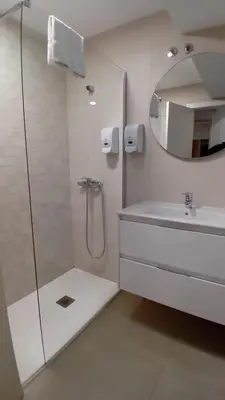 a bathroom with a shower and a sink and a mirror at Amplio piso con terraza en el Camino y Catedral in Santiago de Compostela