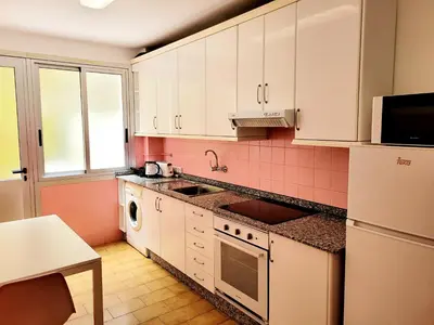 a kitchen with white cabinets and pink tile at Amplio piso con terraza en el Camino y Catedral in Santiago de Compostela