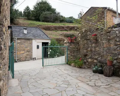 an entrance to a stone building with a gate at Casa Nastasia in A Pontenova