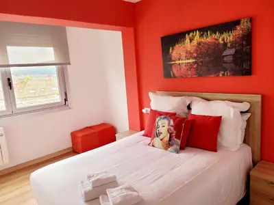 a red bedroom with a bed with a woman on it at AMPLIO PISO LUMINOSO CERCA DEL CAMINO Y CATEDRAL C3 in Santiago de Compostela