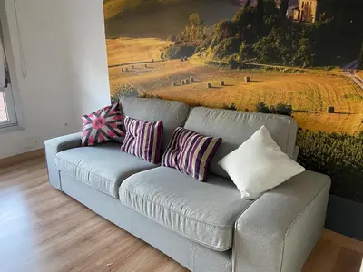 a couch with pillows on it in a living room at AMPLIO PISO LUMINOSO CERCA DEL CAMINO Y CATEDRAL C3 in Santiago de Compostela