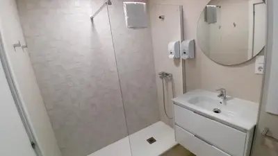 a bathroom with a shower and a sink and a mirror at AMPLIO PISO LUMINOSO CERCA DEL CAMINO Y CATEDRAL C3 in Santiago de Compostela