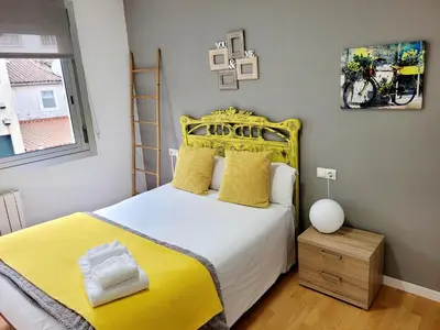 a bedroom with a yellow bed with a yellow headboard at Amplio piso con vistas en la entrada del camino C4 in Santiago de Compostela
