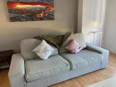 a couch with pillows on it in a living room at Amplio piso con vistas en la entrada del camino C4 in Santiago de Compostela