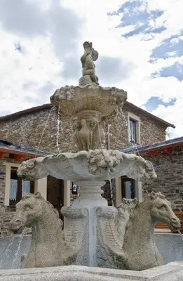 a stone fountain with a statue of horses at Apartamentos Rurales San Xillao in Ribadeo