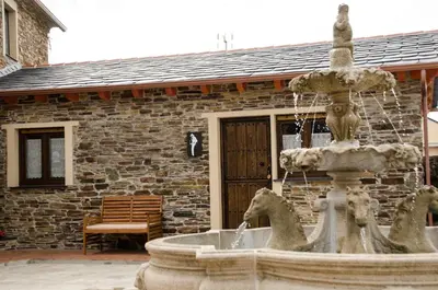 a fountain with three horses in front of a building at Apartamentos Rurales San Xillao in Ribadeo