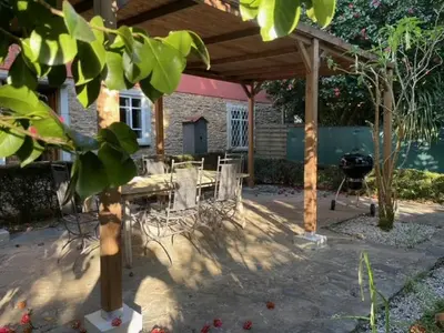 a patio with a table and chairs under a pavilion at Casa Do Bosque in Cabañas