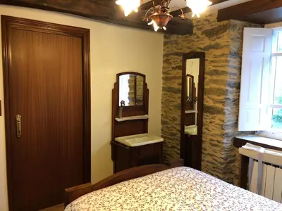 a bedroom with a bed and a sink and a mirror at Casa Do Bosque in Cabañas