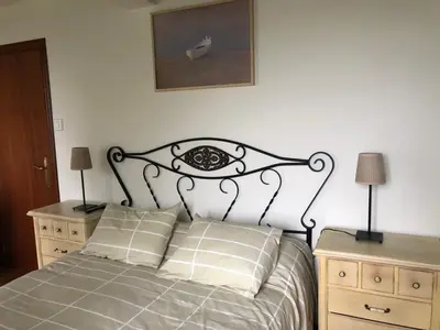 a bedroom with a bed with two night stands and two lamps at Casa Do Bosque in Cabañas