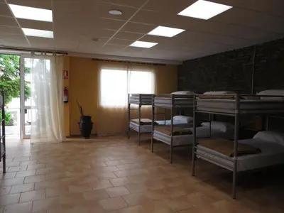 a room with several bunk beds in it with a window at Obradoiro in Sarria