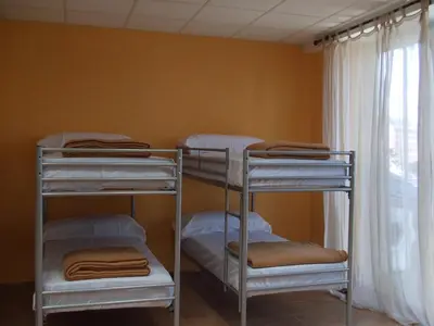 two bunk beds in a room with a window at Obradoiro in Sarria