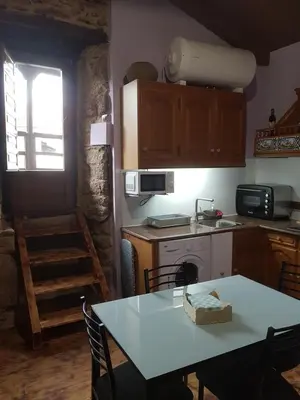 a kitchen with a table and a stove top oven at A Paragűeria in Sas de Penelas