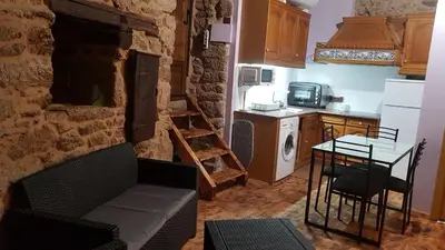 a kitchen with a couch and a table in a room at A Paragűeria in Sas de Penelas