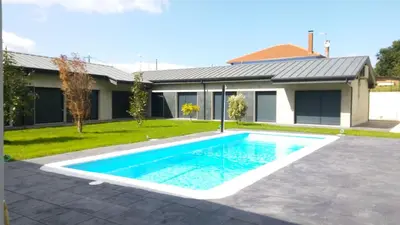 a swimming pool in front of a house at Carballos Altos-Apartamentos Turísticos in Arzúa