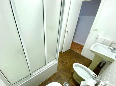 a bathroom with a shower and a toilet and a sink at Garden Lodge Hostal Evencio in Ribadavia