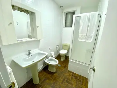 a bathroom with a sink and a toilet and a shower at Garden Lodge Hostal Evencio in Ribadavia