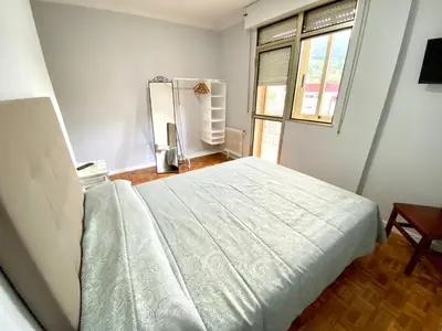 a bedroom with a large white bed in a room at Garden Lodge Hostal Evencio in Ribadavia