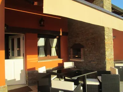 a patio with tables and chairs on the side of a building at APARTAMENTOS FONTE VILLAR in Navia