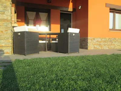 two wicker chairs sitting outside of a house at APARTAMENTOS FONTE VILLAR in Navia