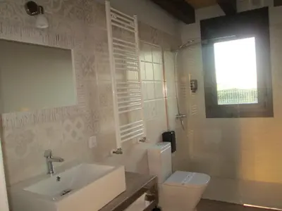 a bathroom with a sink and a toilet and a window at APARTAMENTOS FONTE VILLAR in Navia