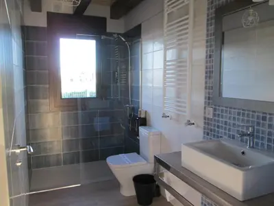 a bathroom with a toilet and a sink and a mirror at APARTAMENTOS FONTE VILLAR in Navia