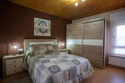 a bedroom with a large bed and a wooden ceiling at Casa Chuss in Sober