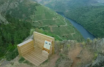 a small building on the side of a mountain next to a river at Casa Chuss in Sober