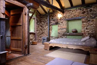 a room with a bed in a stone wall at Louteiro de las Médulas in Orellán