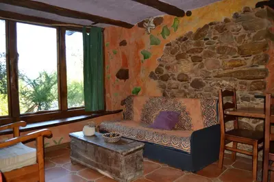 a living room with a couch and a stone wall at Louteiro de las Médulas in Orellán