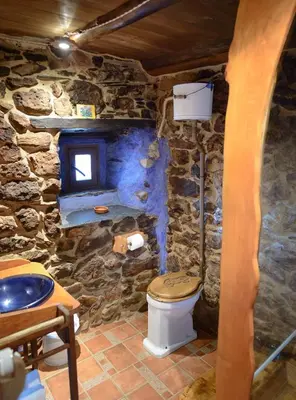a stone bathroom with a toilet and a sink at Louteiro de las Médulas in Orellán
