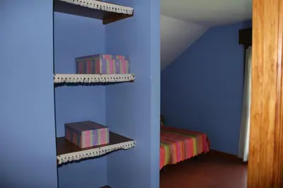 a room with blue walls and a room with a bed at El Aposento De Babia in Quintanilla De Babia