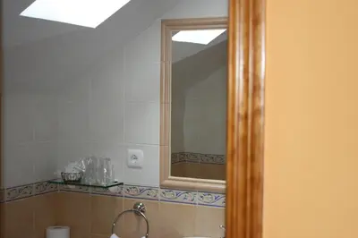 a bathroom with a mirror and a sink at El Aposento De Babia in Quintanilla De Babia