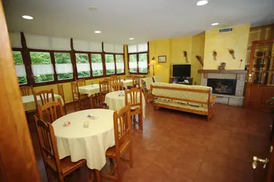 a restaurant with tables and chairs and a fireplace at El Aposento De Babia in Quintanilla De Babia