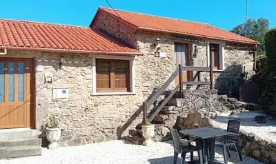 a small stone house with a table and a wooden door at Stone Cottage SANTIAGO in Curtis