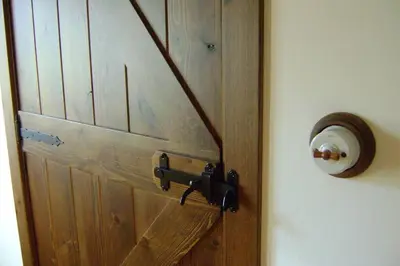 a brown wooden door with aigunigunigun at Stone Cottage SANTIAGO in Curtis