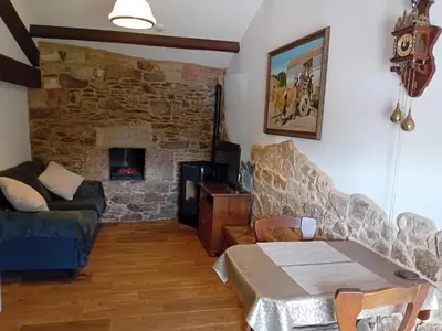 a living room with a couch and a stone wall at Stone Cottage SANTIAGO in Curtis