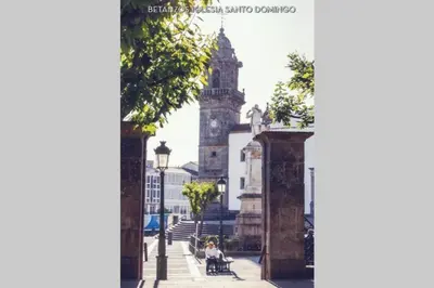 a woman sitting on a bench in front of a building at Stone Cottage SANTIAGO in Curtis