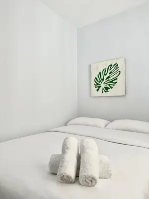 a white bedroom with two beds with towels at Lemos Nube in Monforte de Lemos