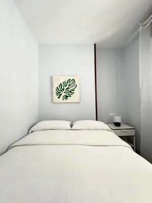 a white bedroom with a white bed and a painting at Lemos Nube in Monforte de Lemos
