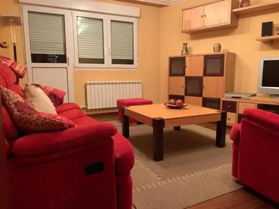 a living room with a red couch and a coffee table at Oktheway San Eufrasio in Sarria