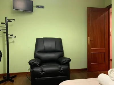 a black leather reclining chair in a room with a television at Oktheway San Eufrasio in Sarria