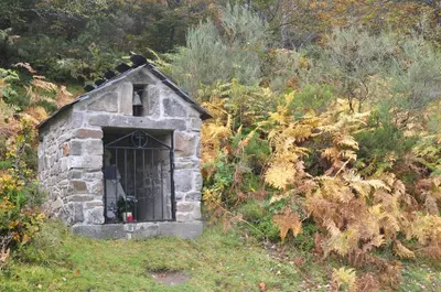 a small stone building with a door in the grass at Apartamentos Rurales Casa Baltasar in Monasterio De Hermo