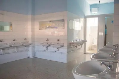 a bathroom with a bunch of sinks and toilets at Albergue Santa Olaia in Silleda