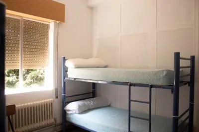 two bunk beds in a room with a window at Albergue Santa Olaia in Silleda